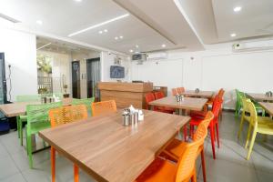 a dining room with wooden tables and colorful chairs at Nova Sahaj Residency in Khirasra