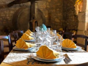 uma mesa longa com pratos, copos e guardanapos em Agriturismo Russa Belladonna em Caltagirone