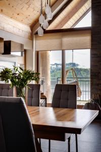 a dining room with a table and chairs and a large window at Apartamenty nad jeziorem, Czorsztyn - Kluszkowce in Czorsztyn