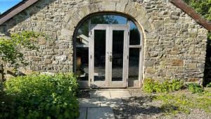 una entrada a un edificio de piedra con puerta en Crug Yr Eryr Isaf en Llandysul