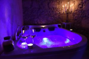 una vasca da bagno viola con bicchieri da vino e candele di Casa Isabella Light Blue Intero Appartamento a Sorso
