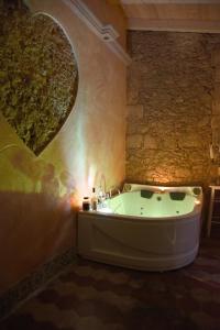 bañera en una habitación con pared de piedra en Casa Isabella Light Blue Intero Appartamento, en Sorso