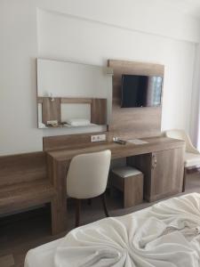 una camera d'albergo con scrivania e specchio di Kleopatra Melissa Hotel a Alanya
