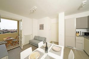 een keuken en een woonkamer met een tafel en stoelen bij Corte Fasanella 31 - Gardagate in Toscolano Maderno