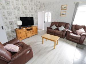 sala de estar con muebles de cuero y TV de pantalla plana en Sean Bhaile en Castlebar