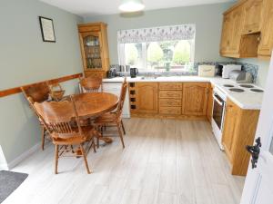 una cocina con armarios de madera y una mesa y sillas de madera. en Sean Bhaile, en Castlebar