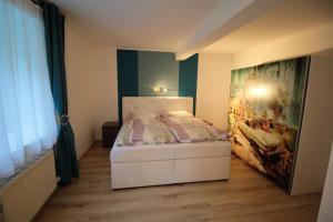 Schlafzimmer mit einem Bett mit Wandgemälde in der Unterkunft Gasthaus Blunzenwirt in Breitenstein