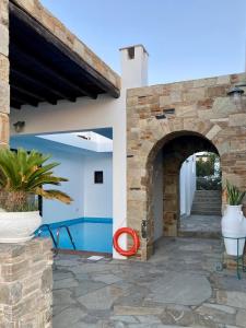 a patio with an archway next to a building at SYROU LOTOS Studios & Apartments in Kini