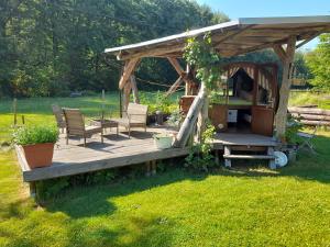 a wooden deck with chairs and a gazebo at Schlummerfass an der Bockmühle in Hohnstein