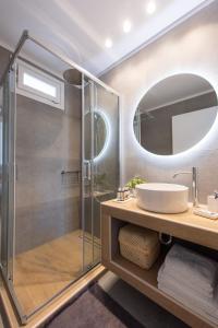 a bathroom with a shower and a sink and a mirror at NIREAS STONEHOUSE IN APOLLONIA SIFNOS in Sifnos