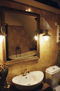 a bathroom with a sink and a mirror and a tub at Mõisa Ait Katusekorter in Võru