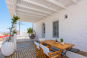 a patio with a wooden table and chairs and a vase at NIREAS STONEHOUSE IN APOLLONIA SIFNOS in Sifnos