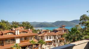 eine Reihe von Häusern auf einem Hügel mit Blick auf das Wasser in der Unterkunft XOX Apart Hotel in Akyaka