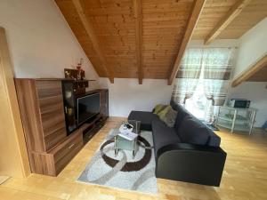 a living room with a black couch and a tv at Ferienwohnung Daberer in Obervellach
