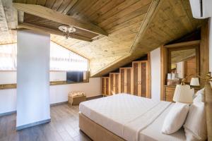 XOX Apart Hotel في أكياكا: غرفة نوم بسرير كبير بسقف خشبي