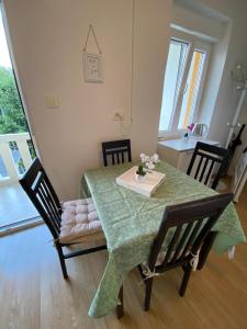 stół jadalny z zielonym stołem i krzesłami w obiekcie Varga apartment w mieście Opatija