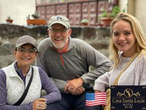 Ein Mann und zwei Frauen sitzen nebeneinander in der Unterkunft Hotel Casa Santa Lucía in Baños