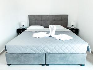 a bedroom with a large bed with two white towels at Fabrica Sunset Apartments in Megali Ammos