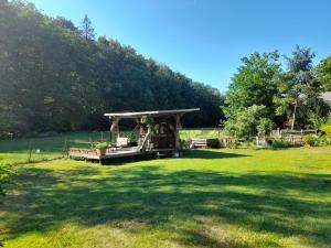 un cenador en medio de un campo de hierba en Schlummerfass an der Bockmühle en Hohnstein