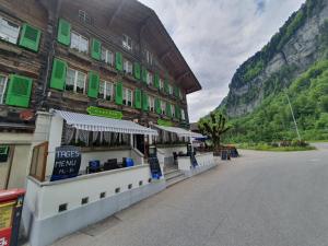 a building with green shuttered windows on a street at Hotel-Restaurant-Linde in Gundlischwand