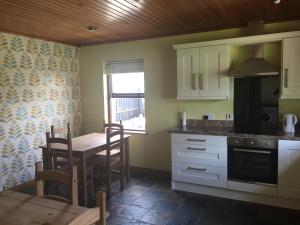 a kitchen with a table and a dining room at Holiday Home in Ballycastle - Fáinne na Cairde in Ballycastle