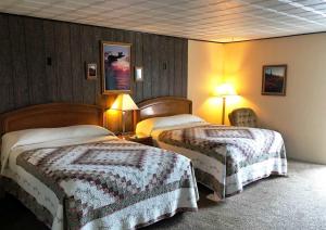 a hotel room with two beds and two lamps at Bristlecone Motel in Ely