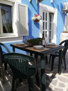 un tavolo e sedie in legno di fronte a una parete blu di Casa vacanze Ombretta a Ponza