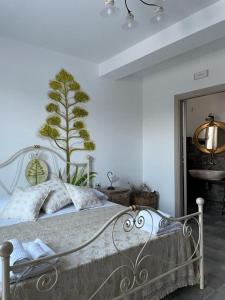 una camera da letto con un letto con una pianta sul muro di Bàcula Nzícula Marzamemi a Marzamemi