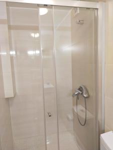 een douche met een glazen deur in de badkamer bij Nas Três Janelas in Viana do Castelo