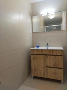 een badkamer met een wastafel en een spiegel bij Nas Três Janelas in Viana do Castelo
