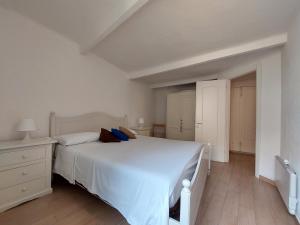 a white bedroom with a bed and a dresser at Mariasole Rooms in Vernazza