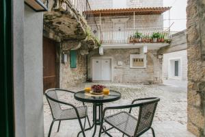 eine Terrasse mit einem Tisch und Stühlen im Innenhof in der Unterkunft Modern traditional apartment w patio near beach in Kaštela