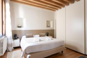 a bedroom with a large white bed in a room at Calle Teatro Vecchio - Venezia in Venice