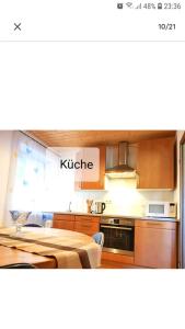 a kitchen with a table and a kitchen with a kitchen at 4 Erw. 1 Ki. Ski Entspannung Terasse Ausblick in Schmallenberg