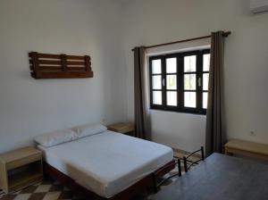 a bedroom with a bed and a window and a table at San Marco Guesthouse in Kattavía