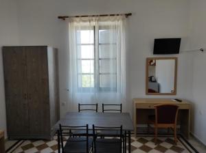 una sala da pranzo con tavolo, sedie e specchio di San Marco Guesthouse a Kattavía