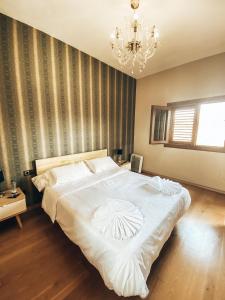 a bedroom with a large white bed with a chandelier at Suite Vistas al Mar in Puerto del Rosario