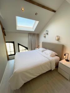a bedroom with a large white bed with a skylight at Casa Clementina - Luxury Penthouse with Airconditioning and Private Terrace in Ghent