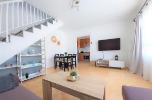 a living room with a couch and a table and a tv at Silver Ocean Puerto Lajas by Sea You There Fuerteventura in Puerto de las Lajas