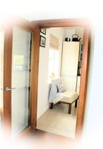 uma vista para um quarto com uma cadeira e um espelho em Cozy & Remote Hideaway Gintys Cottage em Ross Port