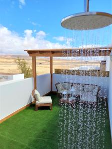a table and chairs on a balcony with a chandelier at Silver Ocean Puerto Lajas by Sea You There Fuerteventura in Puerto de las Lajas