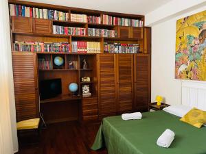 a bedroom with a bed and a book shelf with books at CASA DEL CORSO in Cinisi