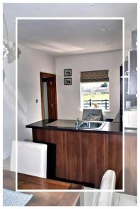 uma cozinha com um lavatório e uma bancada de madeira em Cozy & Remote Cottage -newly renovated em Ross Port