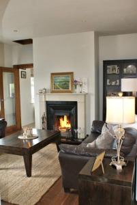 a living room with a couch and a fireplace at Cozy & Remote Hideaway Gintys Cottage in Ross Port