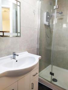 La salle de bains est pourvue d'un lavabo et d'une douche. dans l'établissement The Beech Flat - Self contained one bedroom flat with parking, à Oxford