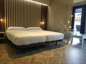 Łóżko lub łóżka w pokoju w obiekcie Apartamentos Turísticos y Habitaciones Cidade Vella by Bossh! Hotels