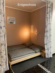 a small bed in a room with curtains at Apartment Pension Sternchen in Erfurt