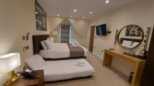 a hotel room with two beds and a mirror at London Star Hotel in London