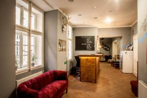 un soggiorno con un divano rosso e una lavagna di Ahoy! Hostel a Praga