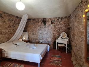 a bedroom with a bed and a table with a mirror at Peacefull and Romantic Hillside House in Jelsa